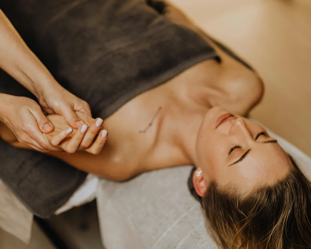 Relaxed woman receiving a wellness massage in a spa treatment — pure relaxation