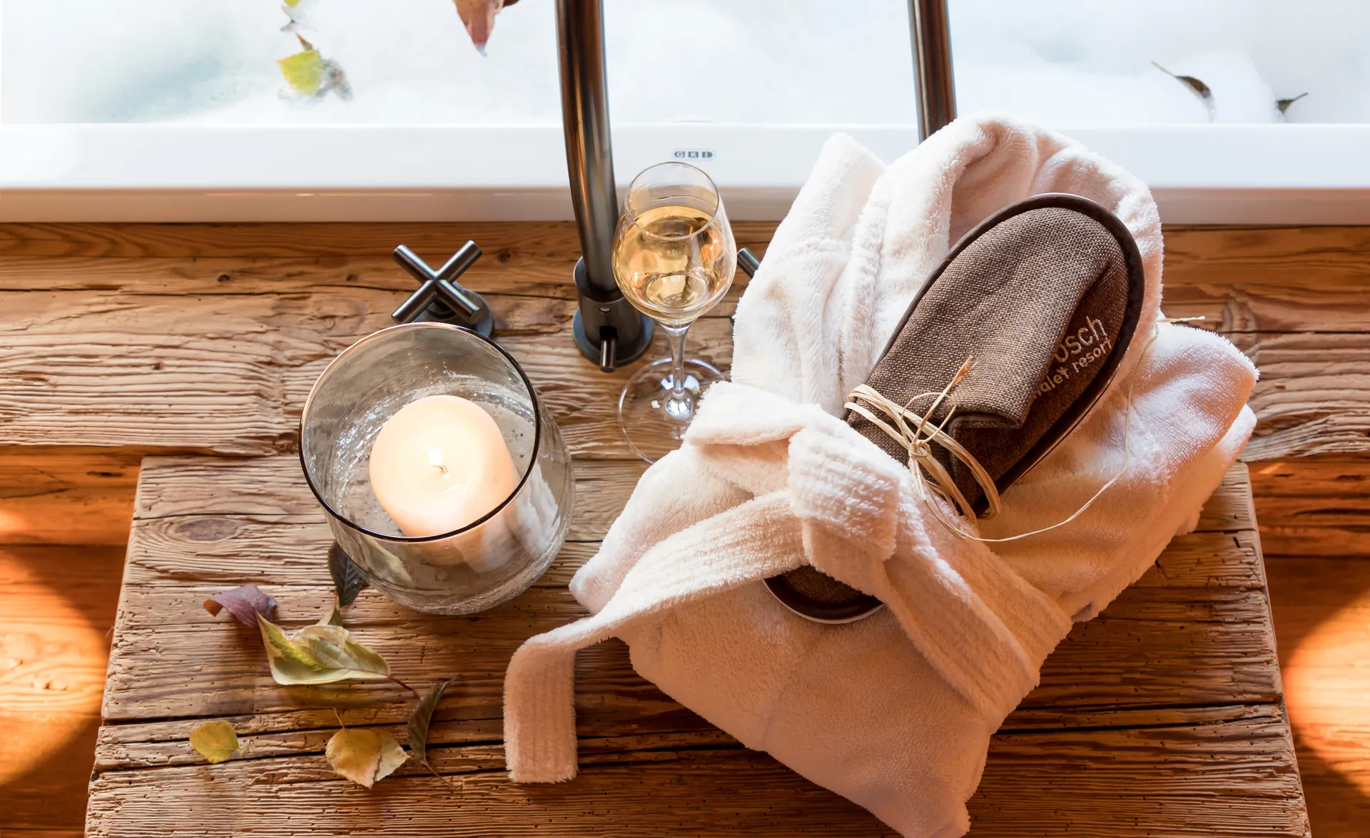 Spa-Stillleben auf Holz-Badewannen-Tablett mit Bademantel, Hausschuhen, Kerze und Weißwein