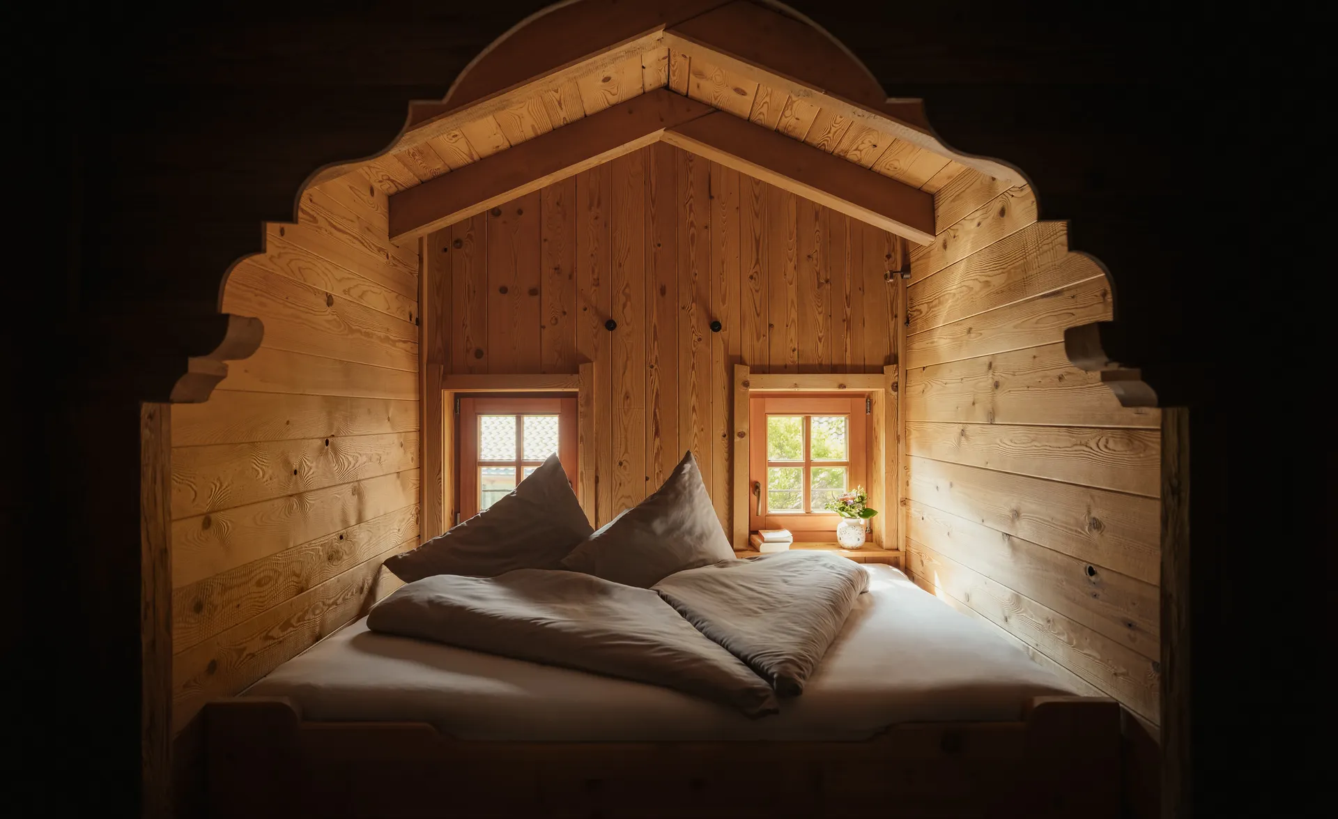 Kuschelige Holzalkovenbett-Nische in einem Zirbenholz-Chalet mit kleinen Fenstern