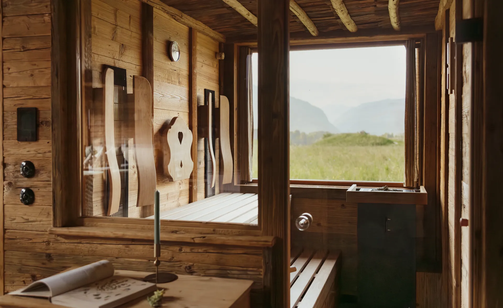 Gemütliche Zirbenholzsauna mit Schnitzlehnen und Panoramafenster zur Alpenlandschaft