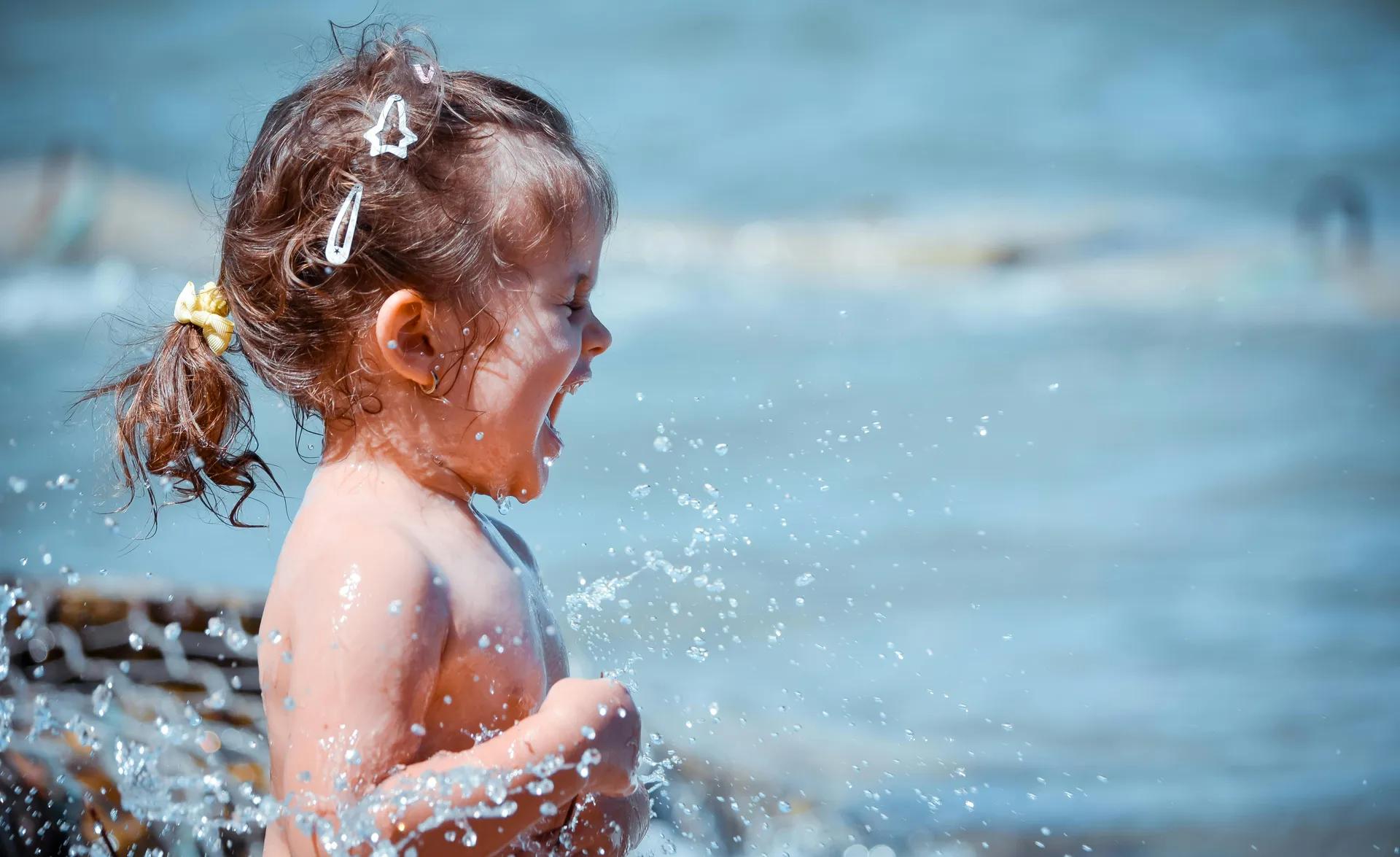 Lachendes Mädchen spritz mit Wasser im Pool — Sommer-Spaß beim LaPosch Familienerlebnis