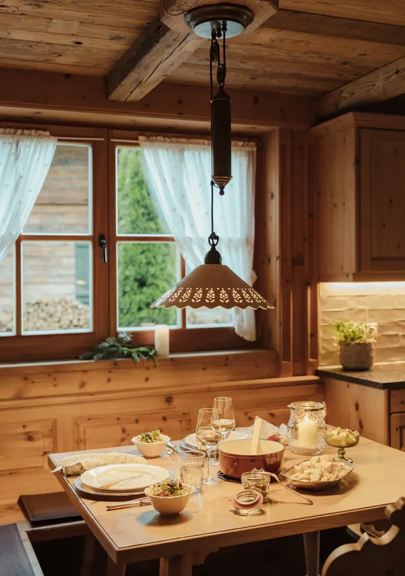 Rustikale Tiroler Chalet-Küche und Essbereich in Kiefernholz mit gedecktem Tisch