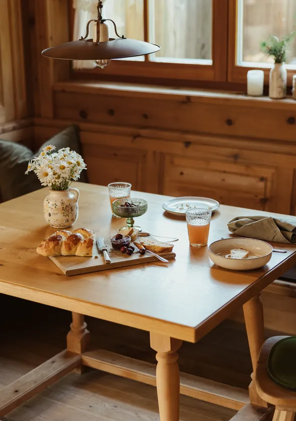 Zirbenholz-Frühstücksnische mit gedecktem Tisch, Konditorwaren und Wildblumen