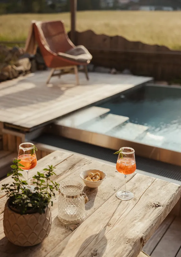Private Terrasse mit Plunge Pool, Korbsessel und Wiesen-Panorama des Chalets
