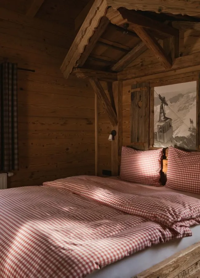 Rustikales Zirbenholz-Schlafzimmer mit eingebautem Bett im Kastenrahmen und Karobettwäsche